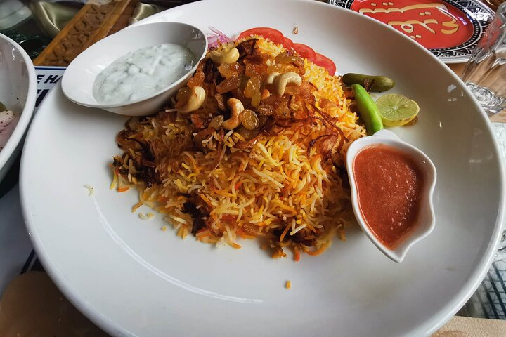 Savor the rich flavors of Dubai with a delightful plate of biryani showcasing the city's diverse culinary heritage. A true taste of local culture awaits around every corner.